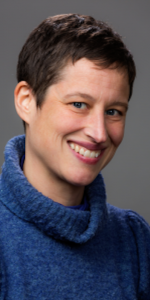 Headshot of Dr Amy Schmid, woman with short brown hair and blue sweater