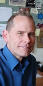 headshot of Dr. David Sherwood, man sitting in an office wearing a blue shirt