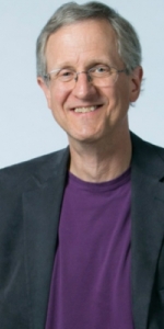 headshot Dr Steve Nowicki, man with white hair and glasses wearing purple shirt and blazeri