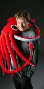 Photo of Dr. Sonke Johnsen with a plush squid wrapped around his shoulders